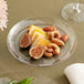 A WNA Comet clear plastic designerware plate with figs, nuts, and cheese on it.