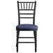 A Lancaster Table & Seating black wood chiavari chair with navy blue cushion.