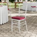 A white wood Chiavari chair with a wine red cushion.
