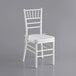 A white Lancaster Table & Seating Chiavari chair with a white cushion.