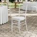 A white wood Chiavari chair with a white cushion.