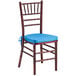 A Lancaster Table & Seating mahogany wood Chiavari chair with a blue cushion.