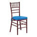 A mahogany wood Chiavari chair with a blue cushion.