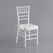 A white Lancaster Table & Seating Chiavari chair with ivory cushion.