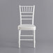 A white Lancaster Table & Seating Chiavari chair with an ivory cushion.