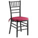 A black Lancaster Table & Seating Chiavari chair with a wine red cushion.