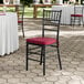 A black wood Chiavari chair with a wine red cushion.
