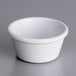 An Acopa white melamine ramekin on a gray surface.