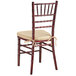 A Lancaster Table & Seating mahogany wood Chiavari chair with gold cushion.