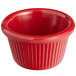 A red fluted melamine ramekin with a white background.