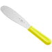 A stainless steel sandwich spreader with a neon yellow handle.