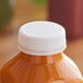 A plastic juice bottle with a White Unlined Tamper-Evident Cap.