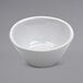 A white irregular ramekin with a shadow on a white background.