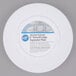 A white Wilton round cake separator plate with a label on it.