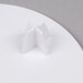 A white Wilton Decorator Preferred 6" Round cake separator plate on a white table.