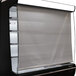 A black Turbo Air air curtain merchandiser with a sliding door.