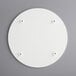 A white circular melamine-coated wood cake board with screws on it.