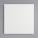 A white square Melamine-coated wood cake board with feet.