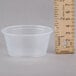 A Dart clear plastic souffle container next to a ruler.