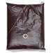 A white plastic bag with a hole in it and a ring of chocolate syrup.