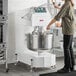 A large commercial spiral dough mixer with a stainless steel bowl and control panel, designed for heavy-duty mixing in bakeries or kitchens.