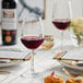 A table with Acopa Radiance wine glasses and food on it.