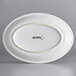 An Acopa Capri coconut white stoneware oval coupe platter with a white border.