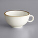 A white stoneware cup with a brown rim.