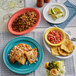 An Acopa Coral Reef oval stoneware coupe platter on a table with food and drinks, including rice, beans, and a bowl of salsa.