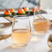 Acopa Radiance tall stemless wine glass filled with wine on a table