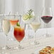 Acopa Elevation glass goblets filled with white and red wine on a table.