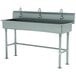 A stainless steel Advance Tabco multi-station hand sink with faucets.