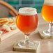 Two Acopa Select Belgian beer glasses on a table.