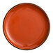 A large, round, orange stoneware coupe plate.