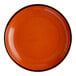 A round, orange stoneware coupe plate with a dark rim.