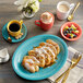 A plate of food and a cup of coffee on a table with a Capri coral reef mug.