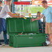 Two men standing next to a green CaterGator outdoor cooler.