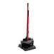 A red and black Libman Deluxe lobby broom in a black stand.