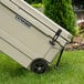 A CaterGator tan mobile outdoor cooler on the grass.