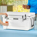 A man and woman using a CaterGator white jockey box to pour beer into plastic cups.