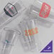 A set of four clear, customizable 20 oz. plastic stackable cooler glasses, each featuring a different printed logo.