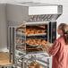 A woman putting food into a Moffat Turbofan convection oven.