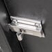 Close-up of a metal latch on a black surface.