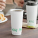 Two EcoChoice white paper hot cups filled with coffee on a table.