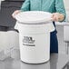 A person holding a white Choice ice bucket with ice inside.