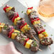 EcoChoice wooden skewers with grilled beef and pineapple on a grey plate.