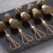Bamboo skewers with meatballs on a plate.