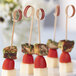 A plate of food with EcoChoice red bamboo skewers holding cheese and tomatoes.