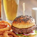 A burger and onion rings with a Bamboo by EcoChoice meat marker on a table.