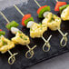 food on skewers on a black plate